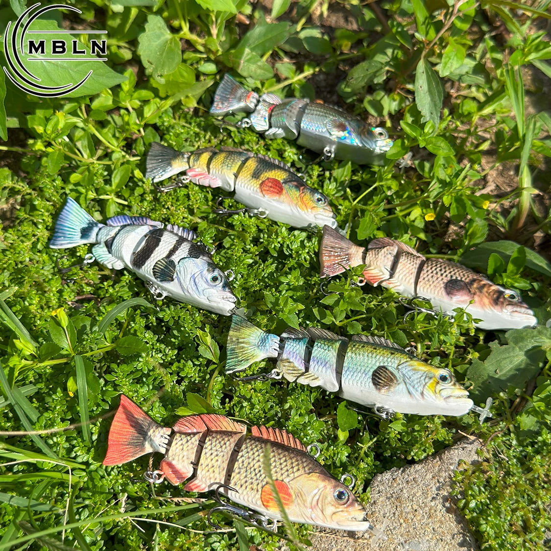 Auto swimming fishing lure for bass set with realistic multi-segmented fish designs on green grass