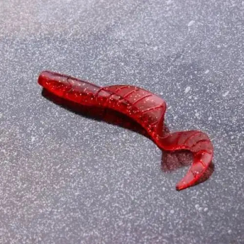 Red plastic fishing lure with a curly tail.