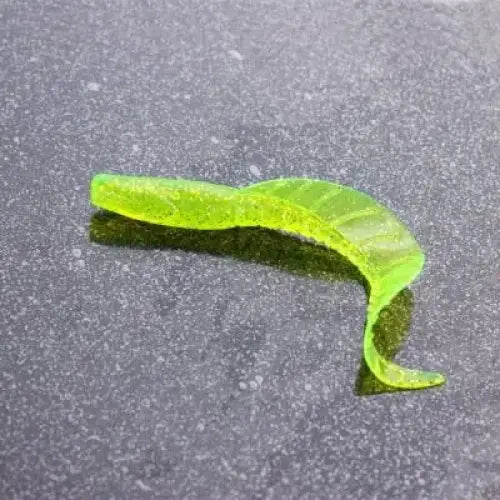 Translucent chartreuse curly tail fishing lure.