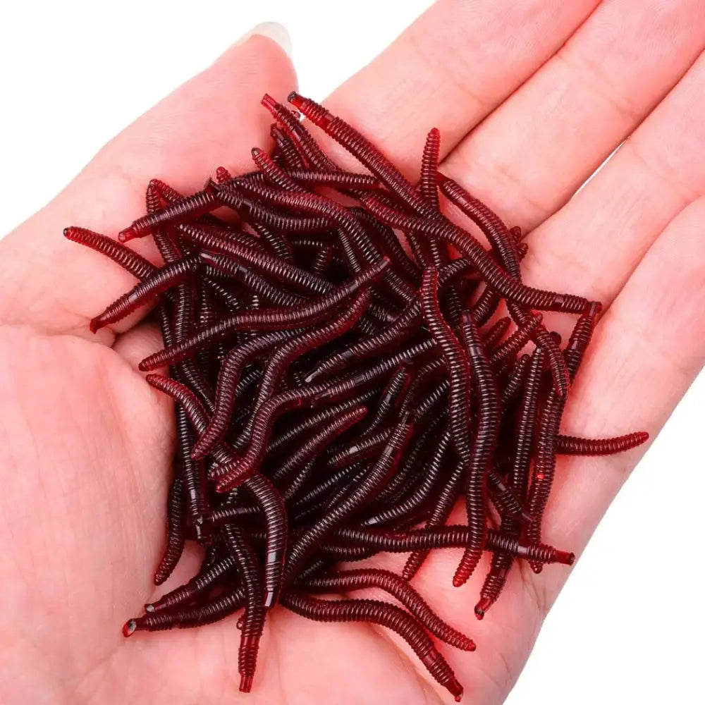 Handful of red, segmented, artificial fishing worms.