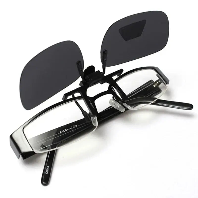 Black clip-on sunglasses over eyeglasses.